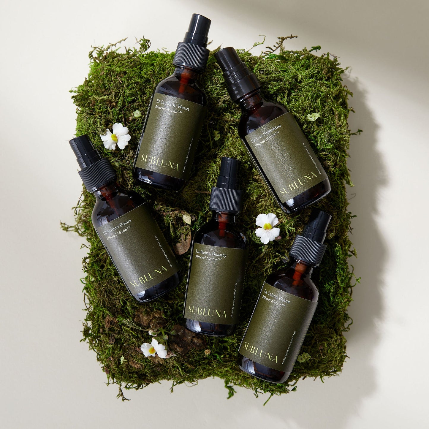 Collection of Subluna Mineral Nectar spray bottles on moss background, natural wellness range now available at Born Primal in Australia
